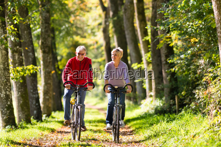 older man and a woman exercising outdoors with their wheels; they are a couple