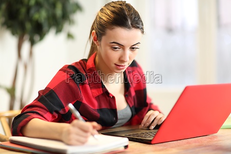 Concentrated student e-learning using laptop and taking notes at home
