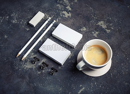 Photo of blank stationery set and coffee cup on concrete background. Corporate identity template.