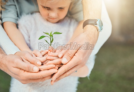Family love is never broken. a unrecognizable family holding plants growing out of soil