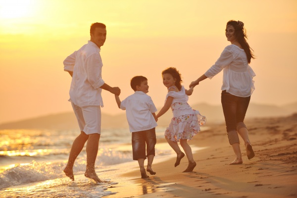 felice giovane famiglia divertirsi sulla spiaggia