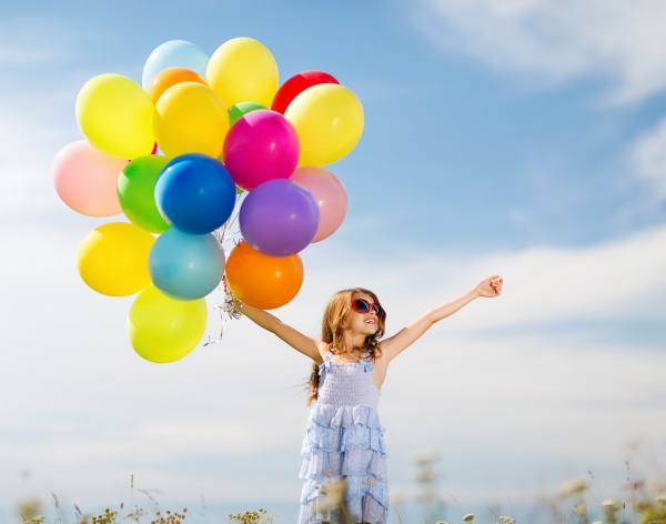 glad pige med farverige balloner