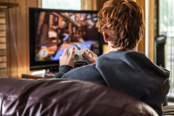 adolescente jugando videojuegos en casa