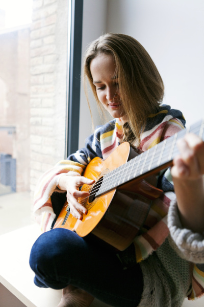 mloda kobieta gra na gitarze