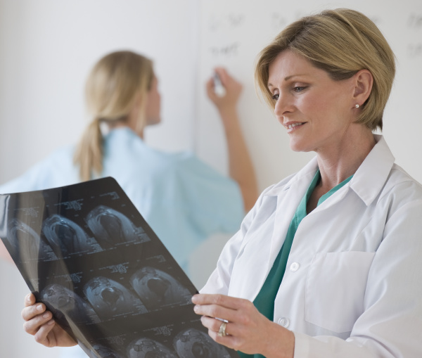 kobieta lekarz patrzac na zdjecia rentgenowskie