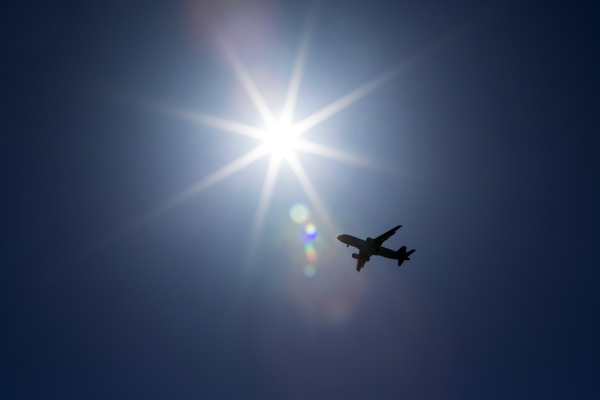 silhuet af fly mod en solstrale