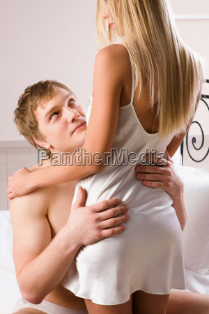 Photo of handsome man embracing his wife and looking at her