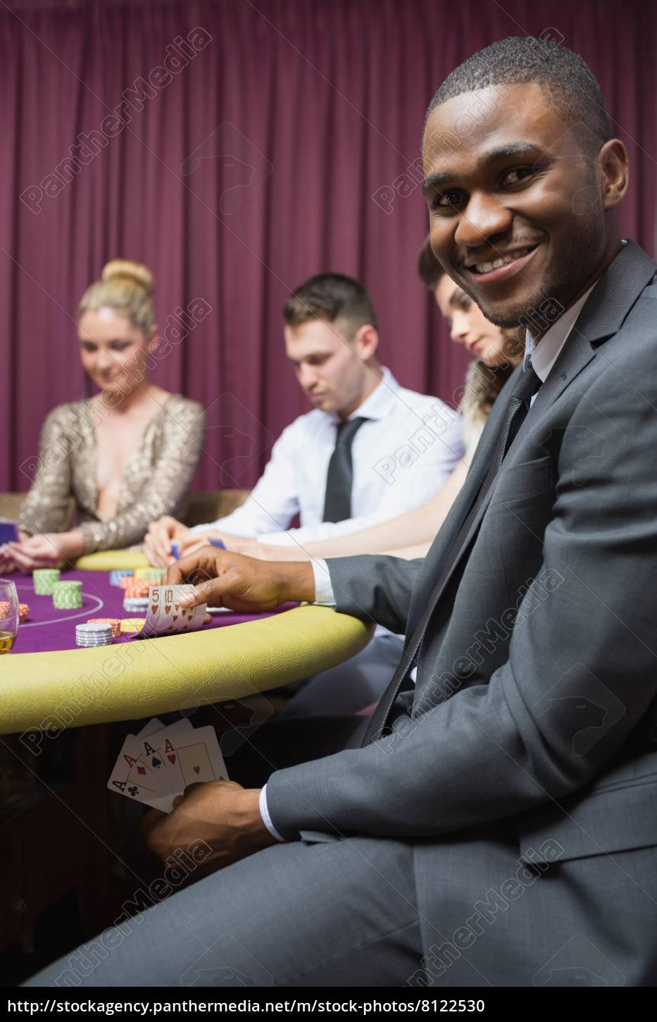 ~man-showing-poker-hand-under-table_08122530_high.jpg