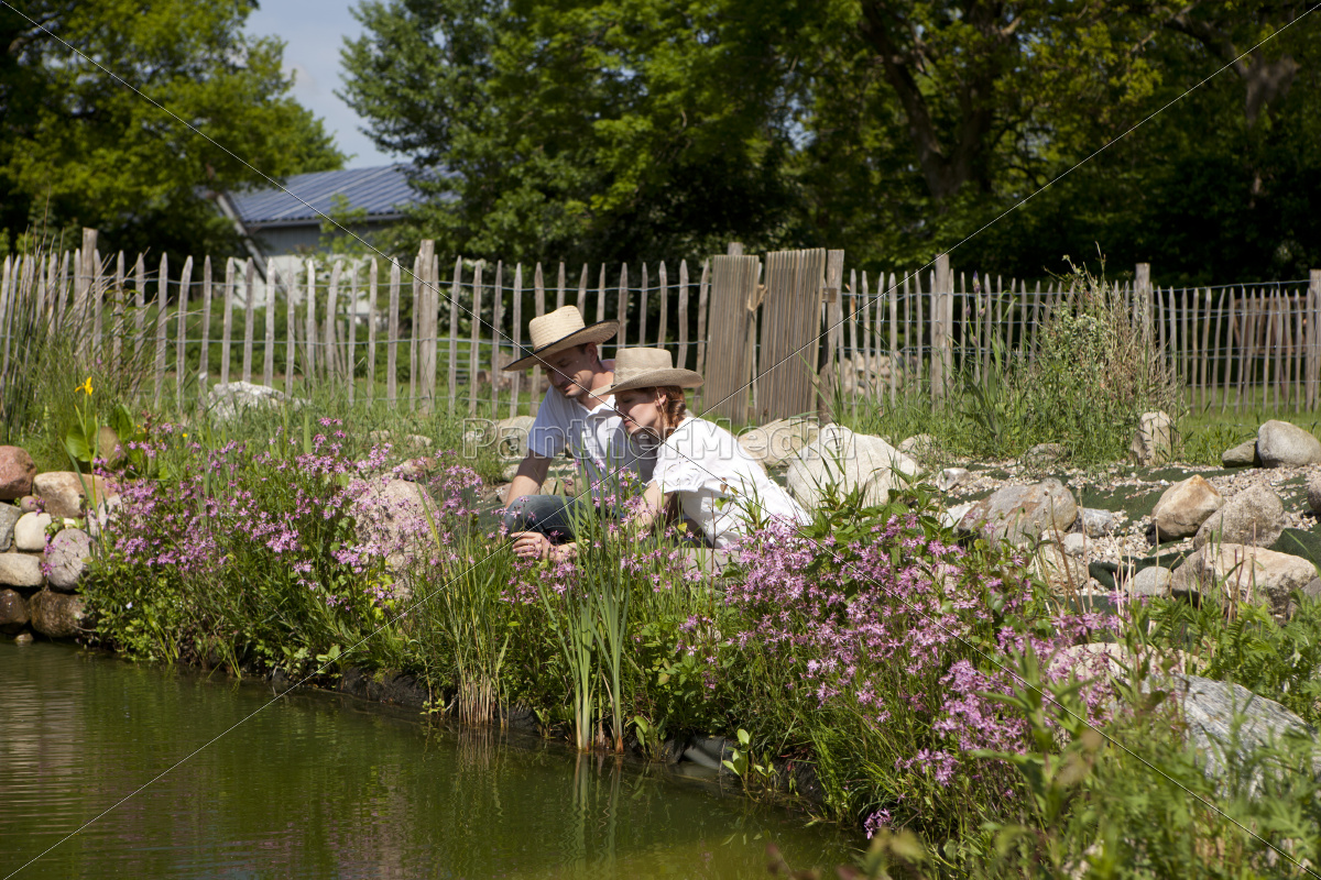 pareja con sombrero de paja en el estanque de jardín - Stockphoto #9664488  | Agencia de stock PantherMedia