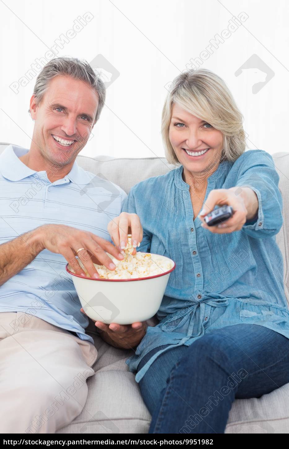 Casal assistindo TV e comendo pipoca no sofá - Stockphoto #9951982 | Banco  de Imagens Panthermedia