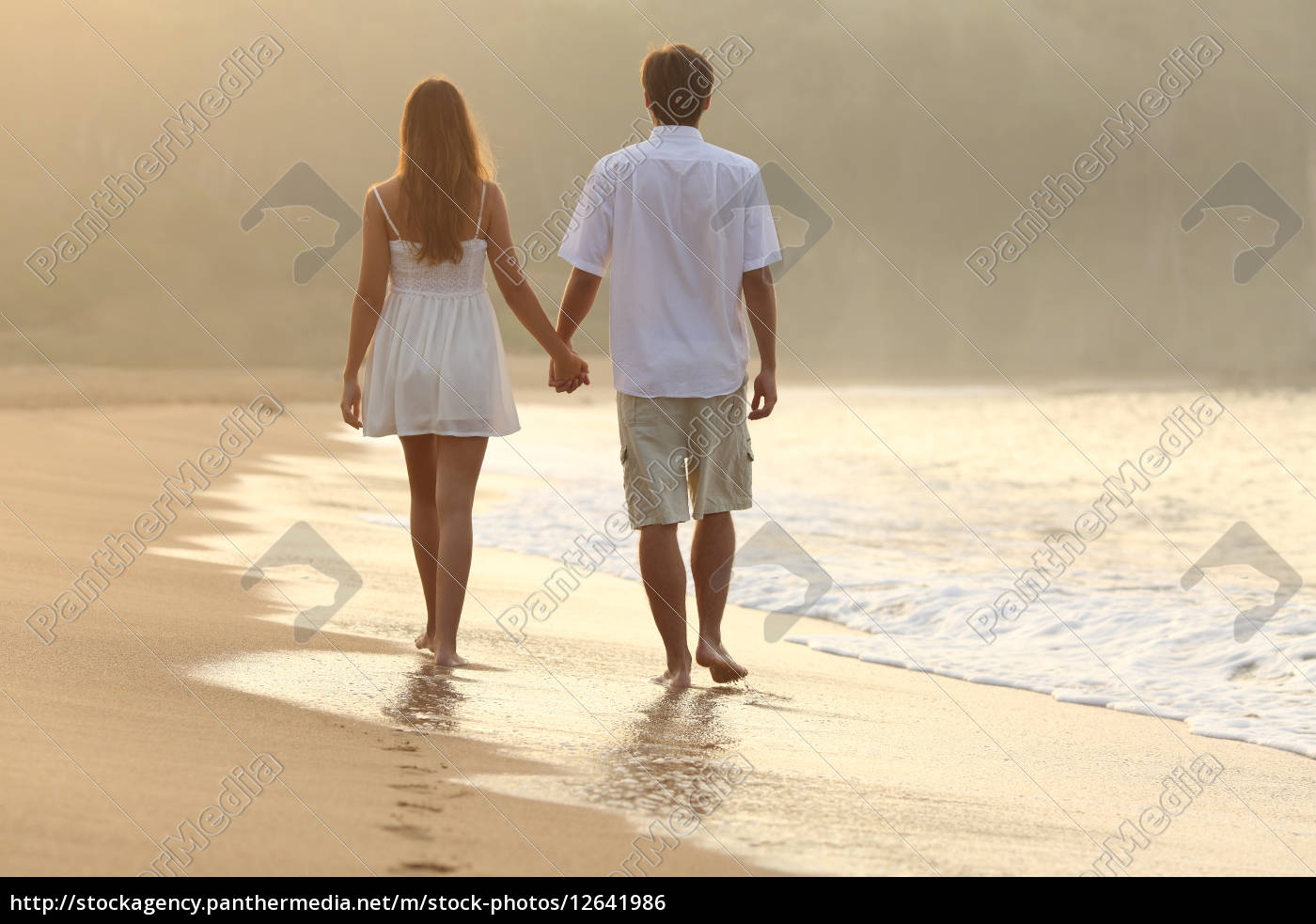 Pareja caminando y cogidos de la mano en la arena de - Stockphoto #12641986  | Agencia de stock PantherMedia