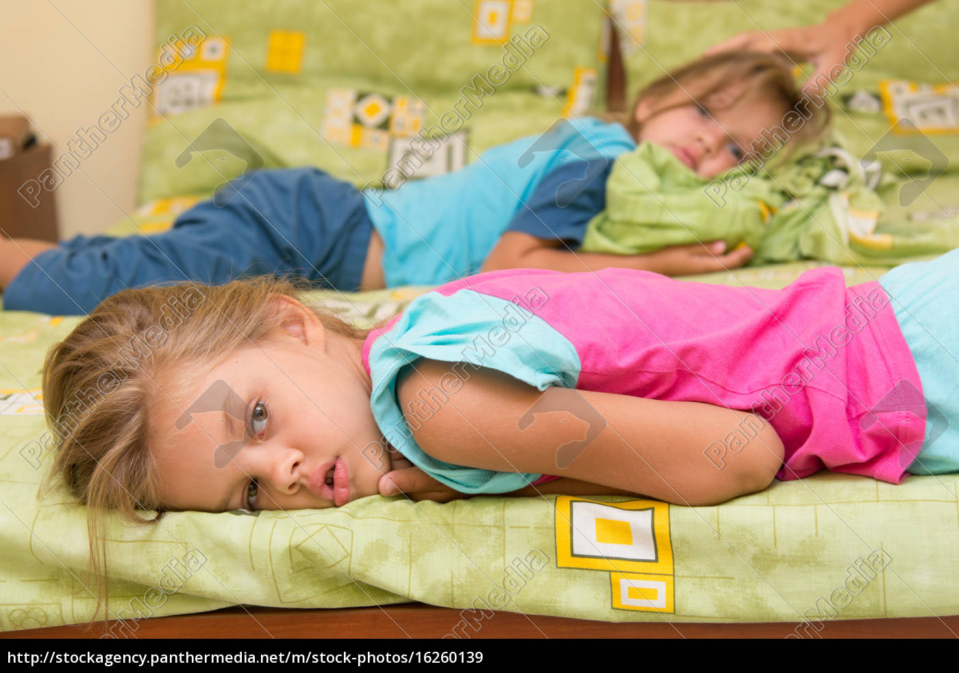 Dos chicas yacen en una cama en los lados opuestos - Foto de archivo  #16260139 | Agencia de stock PantherMedia