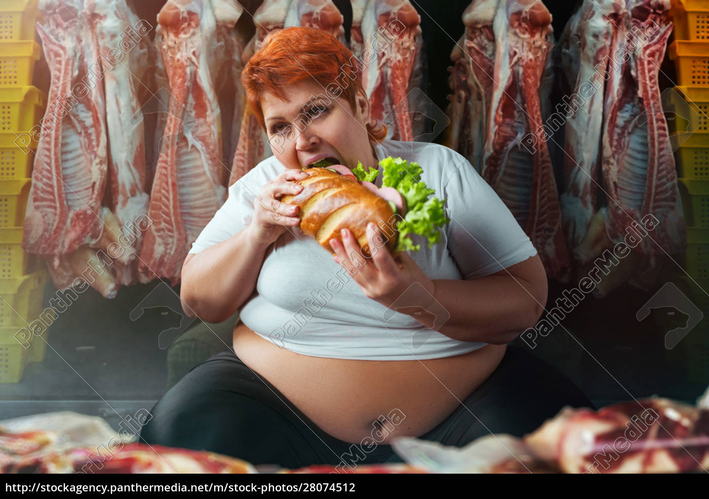 Fat woman eating burger against meat carcasses - Royalty free photo  #28074512 | PantherMedia Stock Agency