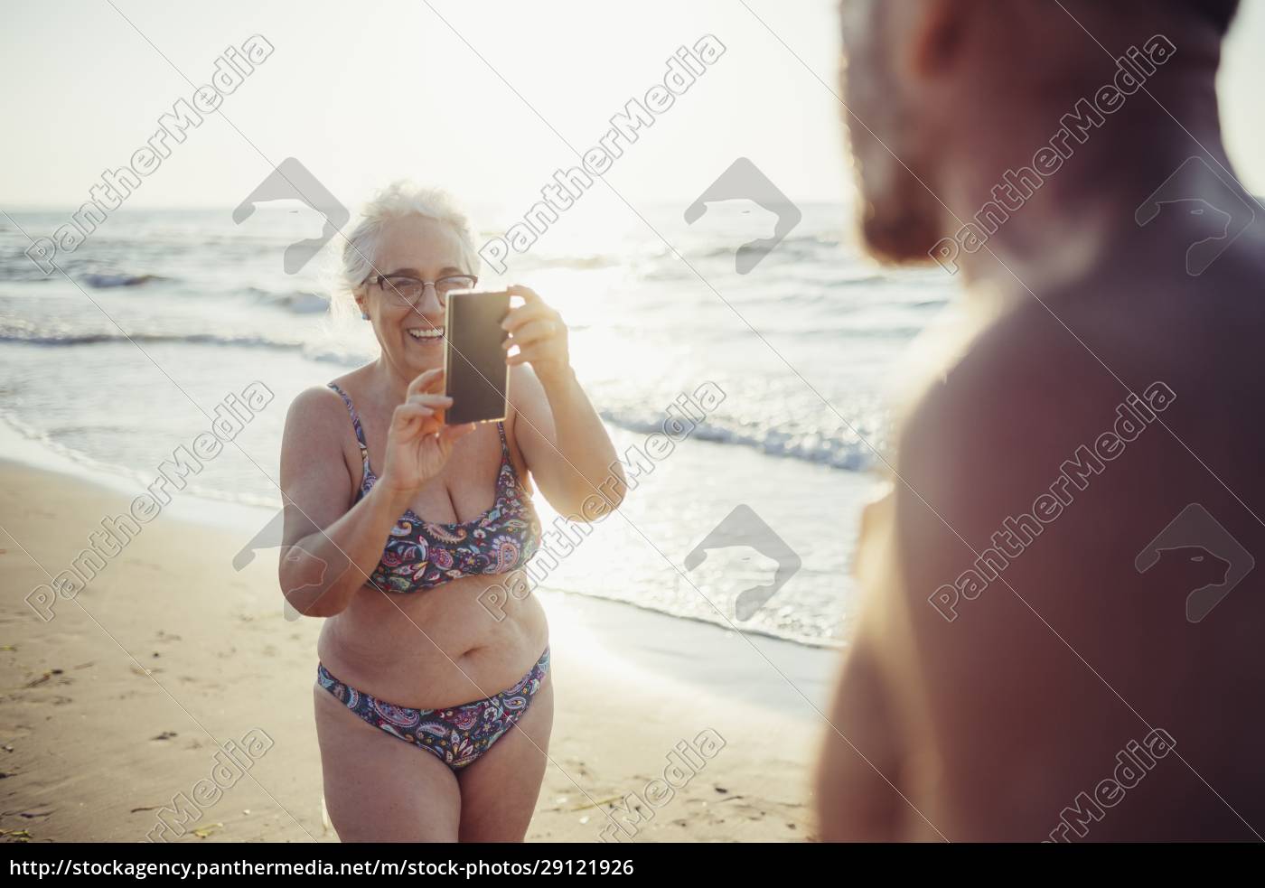 Idosa de biquíni tirando foto de homem enquanto - Stockphoto #29121926 |  Banco de Imagens Panthermedia